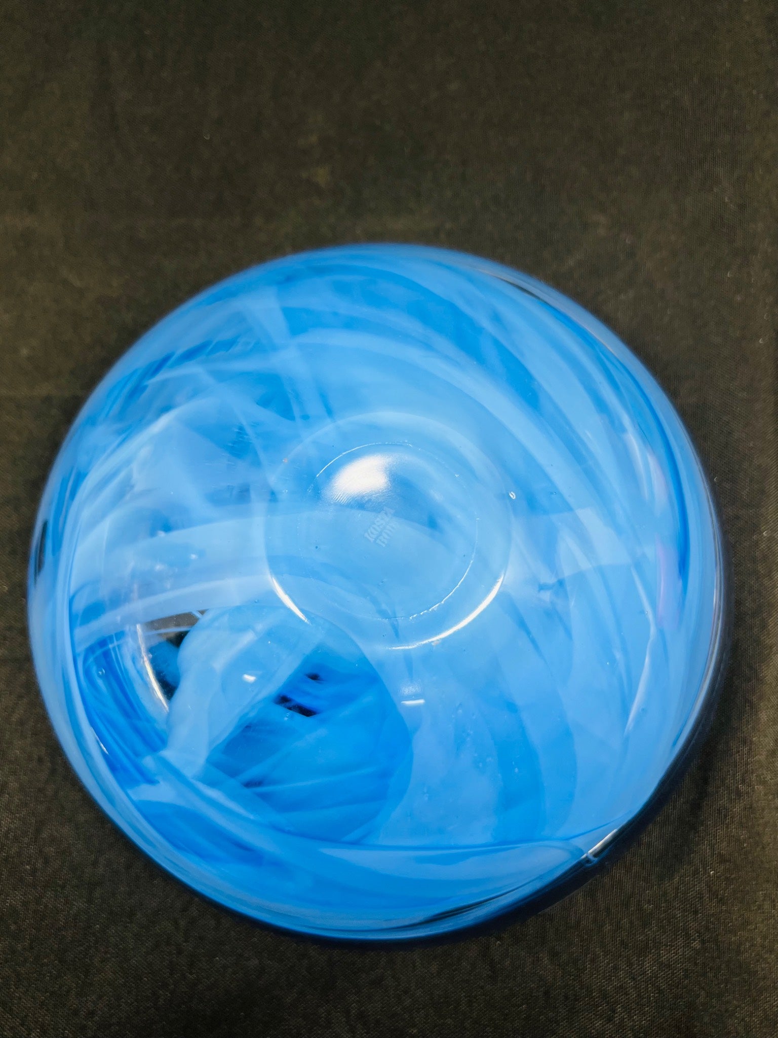 Blue ball with white strings on a dark surface