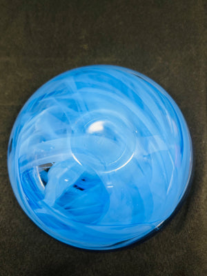 Blue ball with white strings on a dark surface