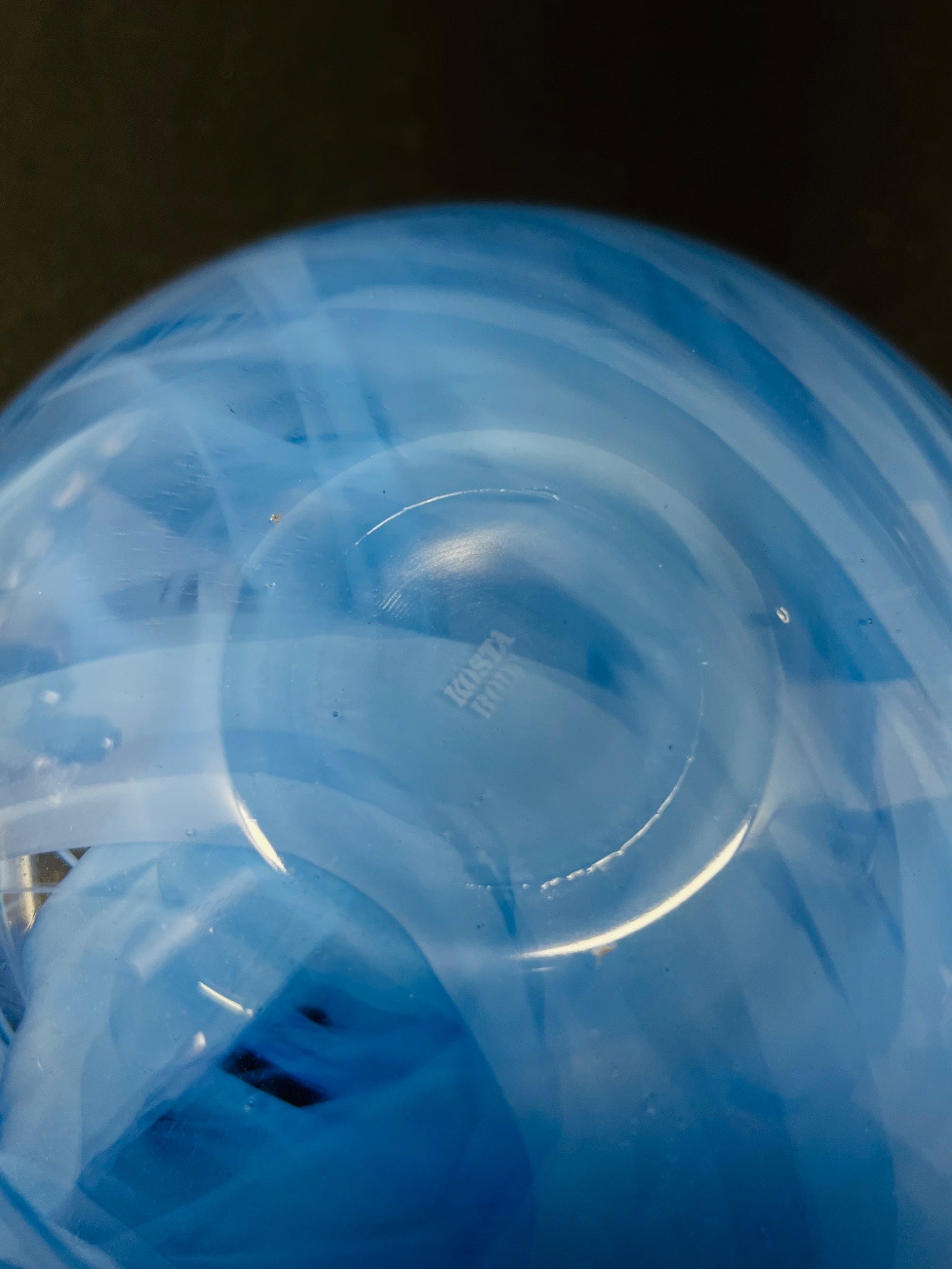 Close-up of a blue plastic container with a clear lid on a dark background