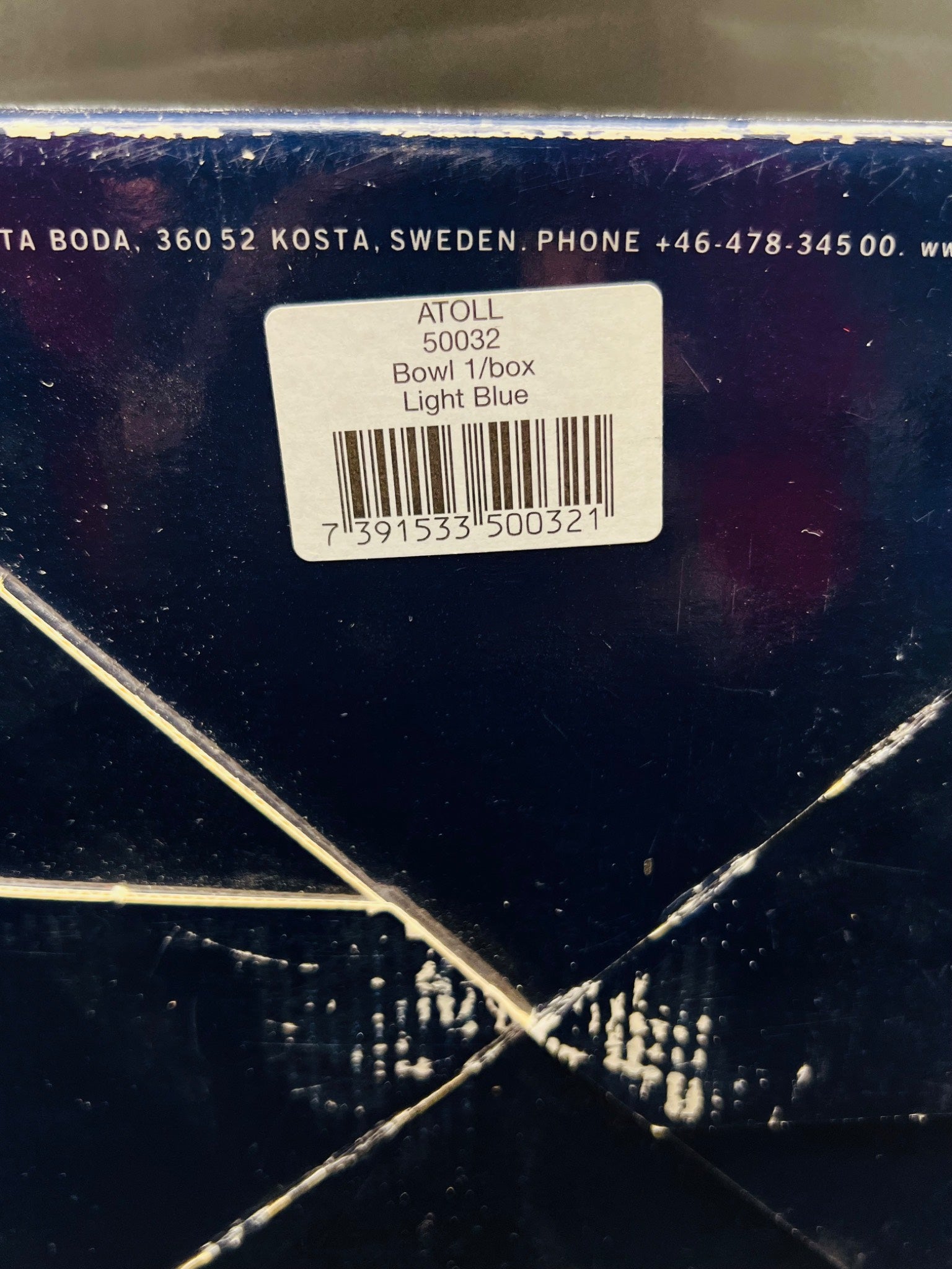 Close-up of a product label on a dark surface with visible text and bar code.