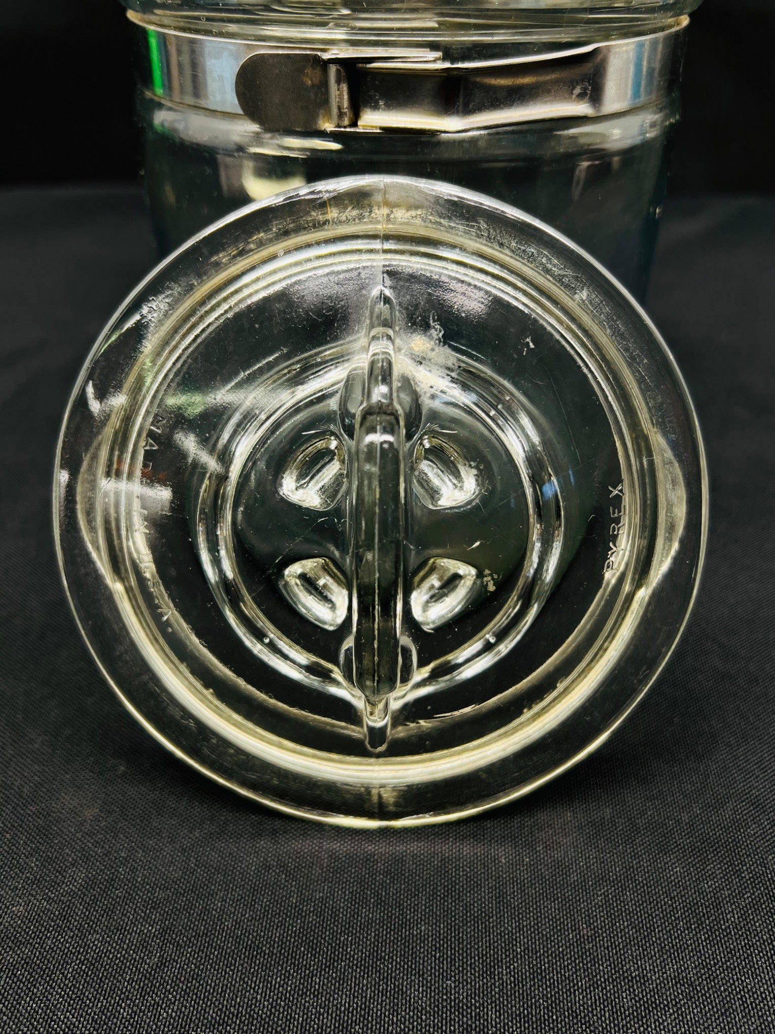 Clear glass jar with a decorative lid on a black background