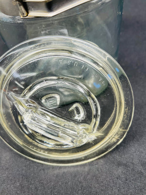 Close-up of a glass water bottle cap with 'U.S.A.' text on a gray background