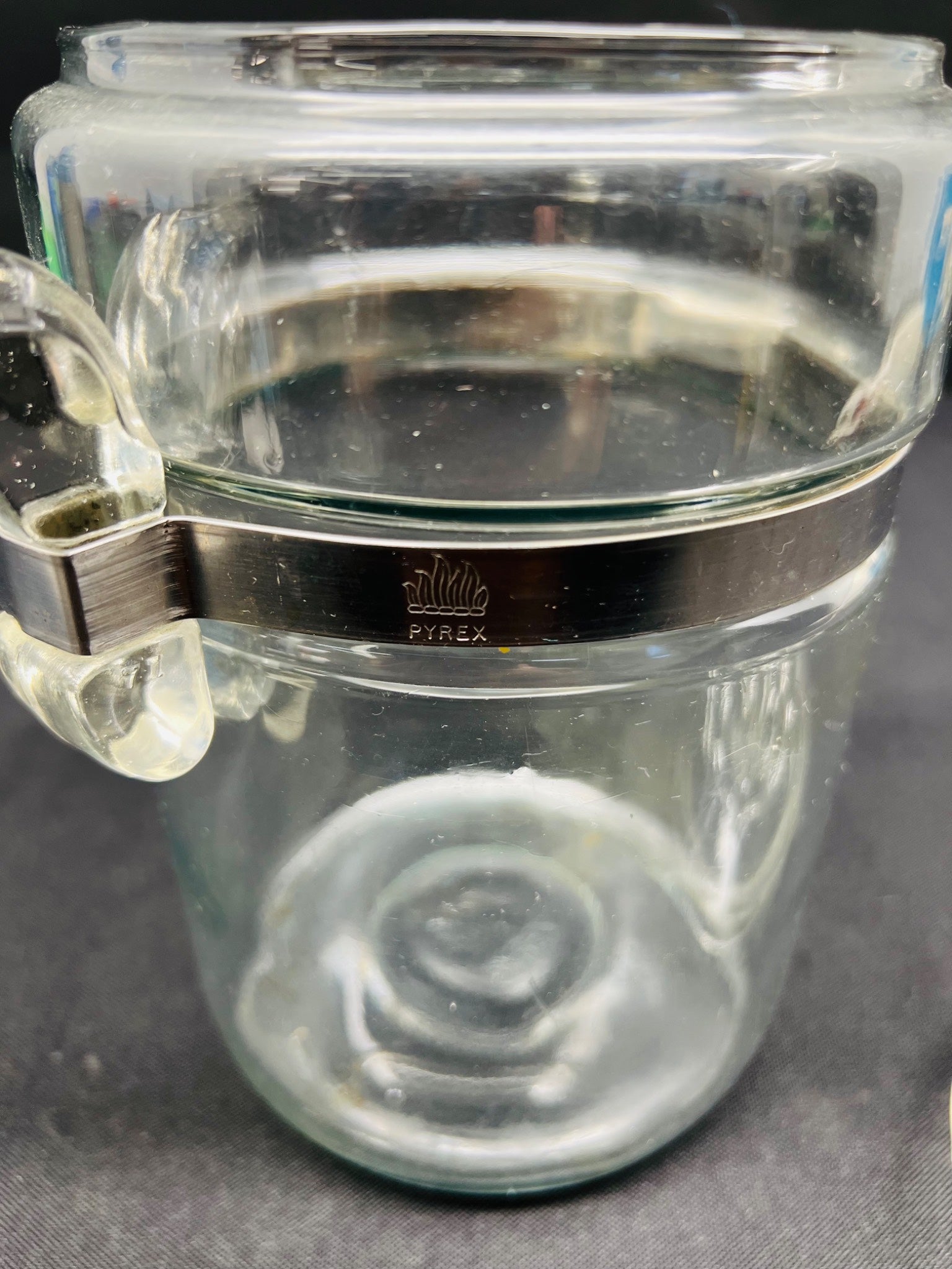Clear glass jar with a metal clasp on a dark background