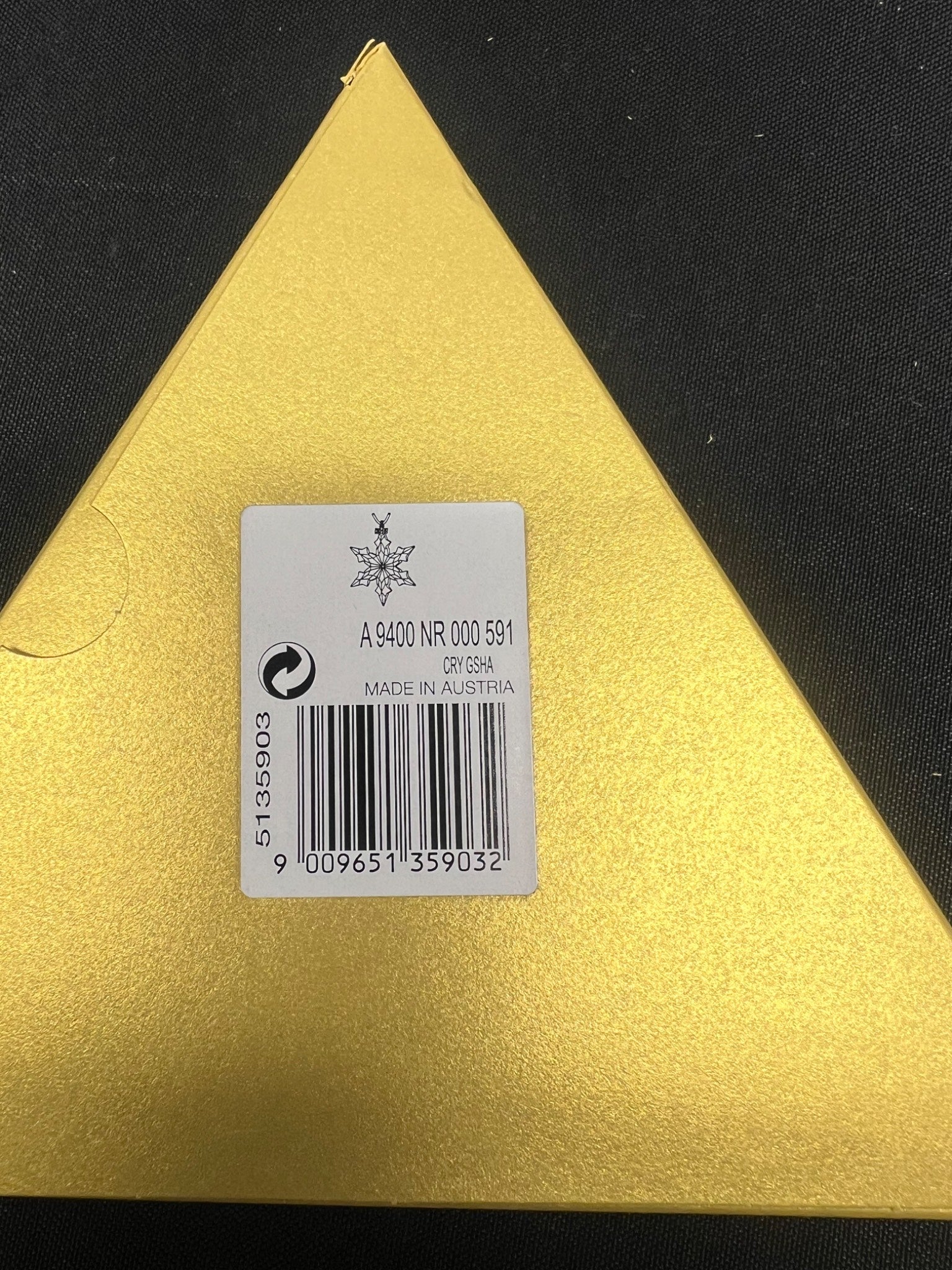 Gold triangular object with a label on a black background