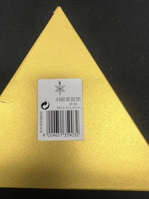 Gold triangular object with a label on a black background
