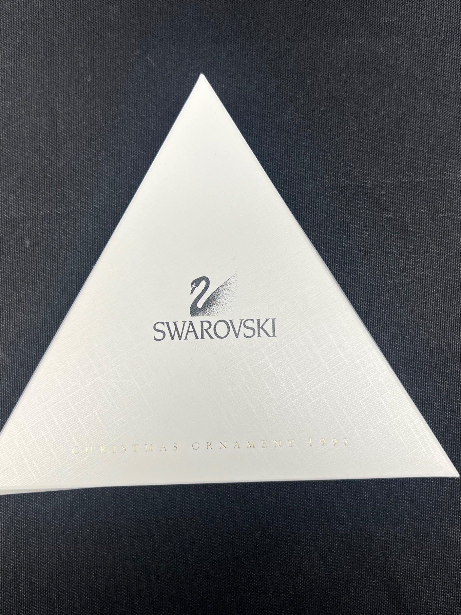 White triangular Swarovski product on a dark background