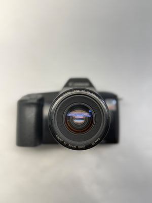 Black camera with lens on a light gray background