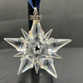 Crystal star-shaped ornament with '2001' on a dark background