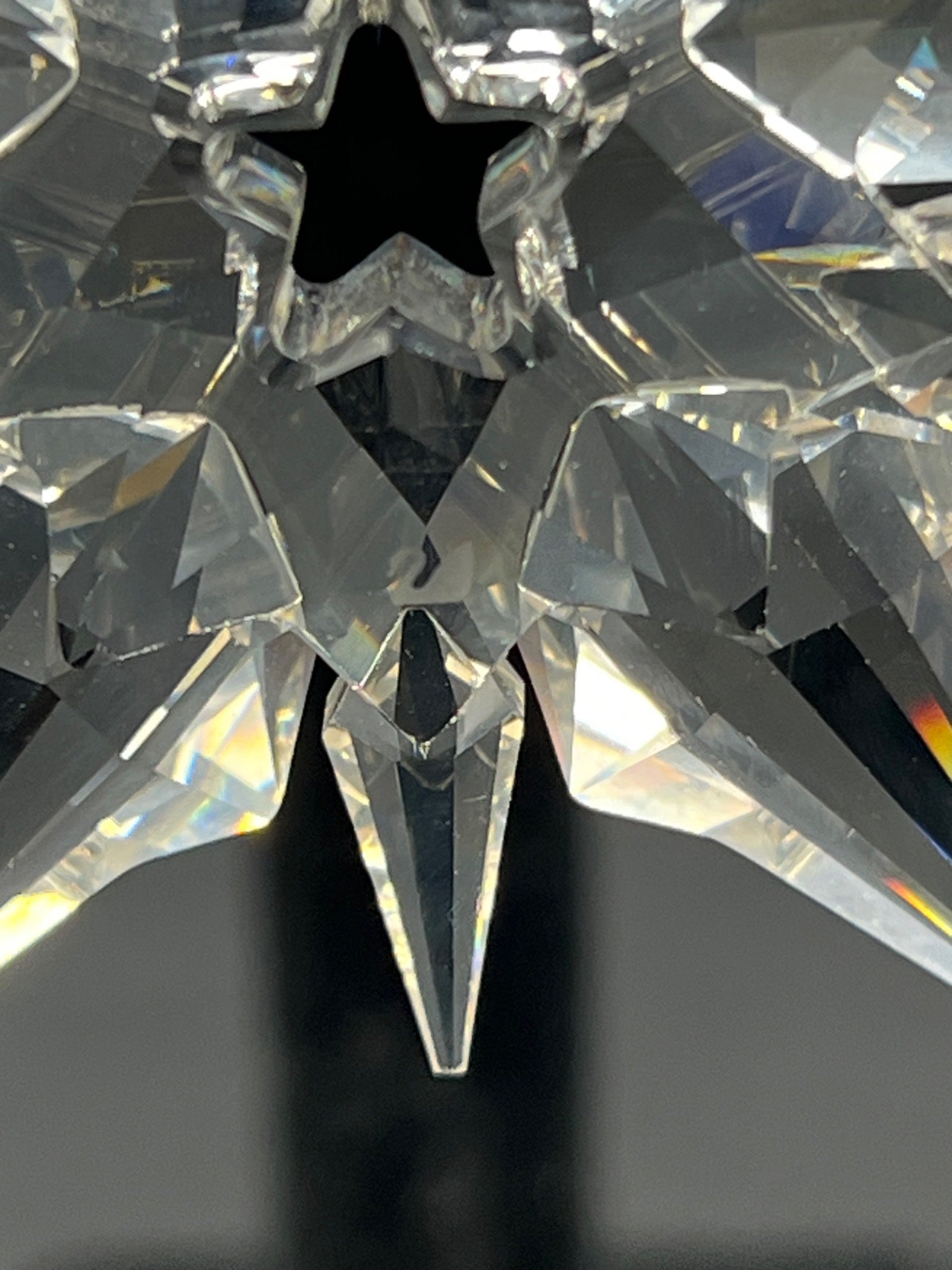 Close-up of a crystal object with star-like design on a dark background