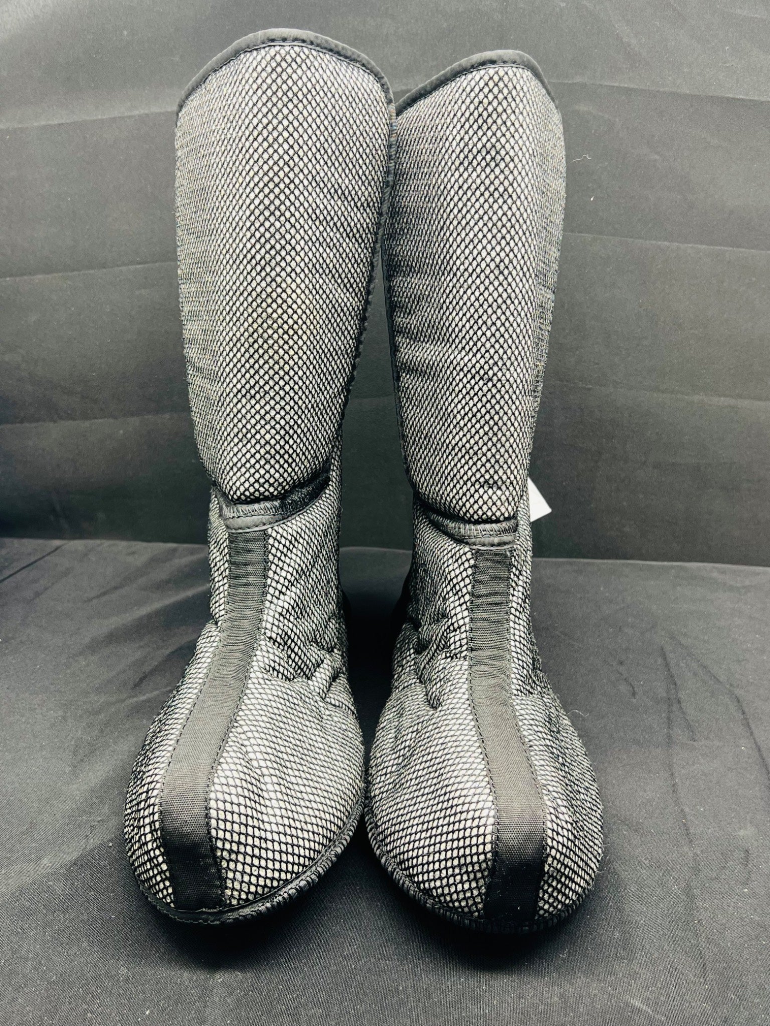 Pair of gray mesh boots on a black background