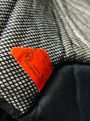 Close-up of a red label on a textured black and gray surface