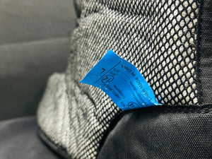 Close-up of a textured fabric surface with a blue tag attached.