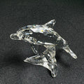 Clear glass dolphin figurine on a black background