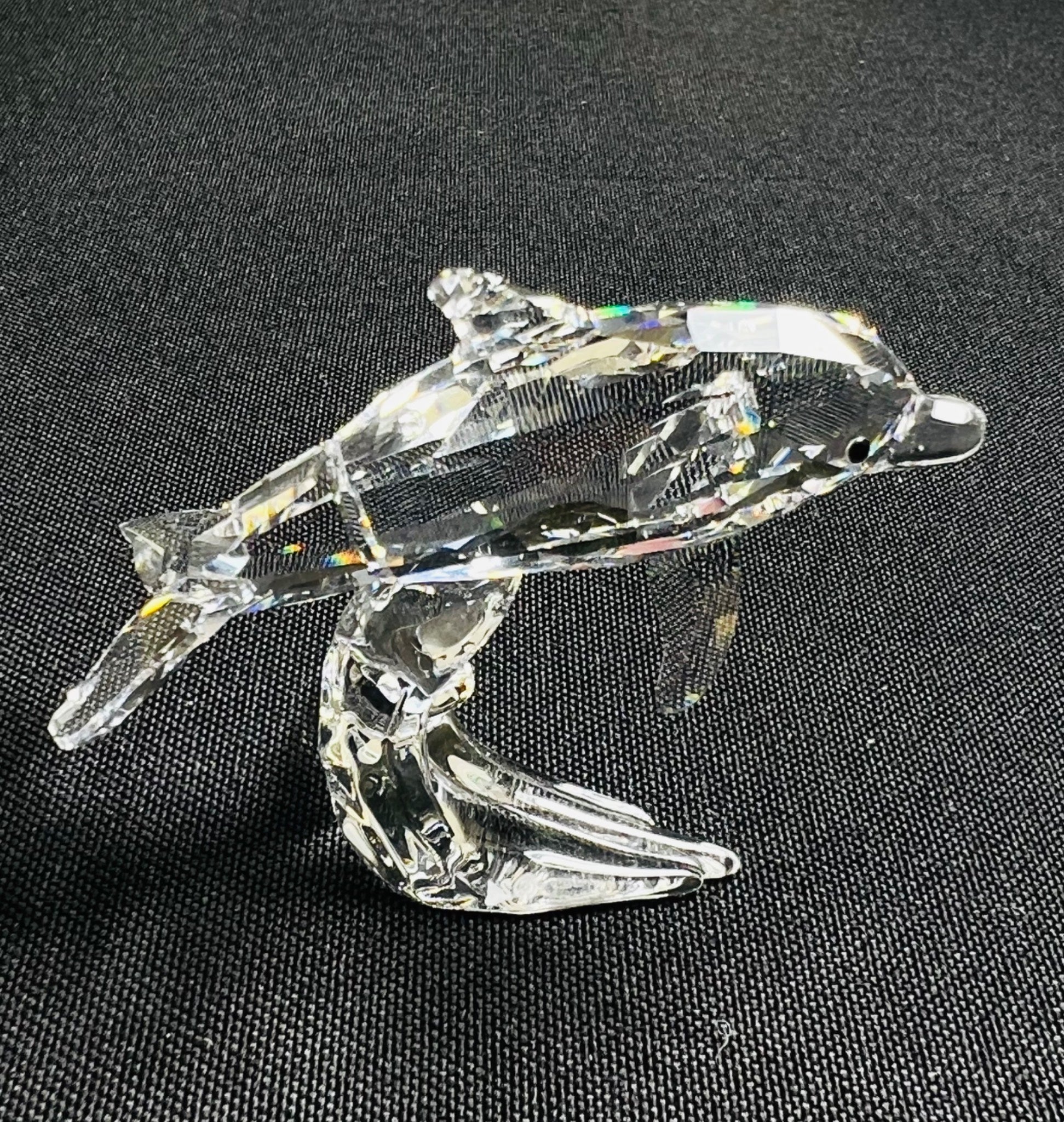 Crystal dolphin figurine on a black background