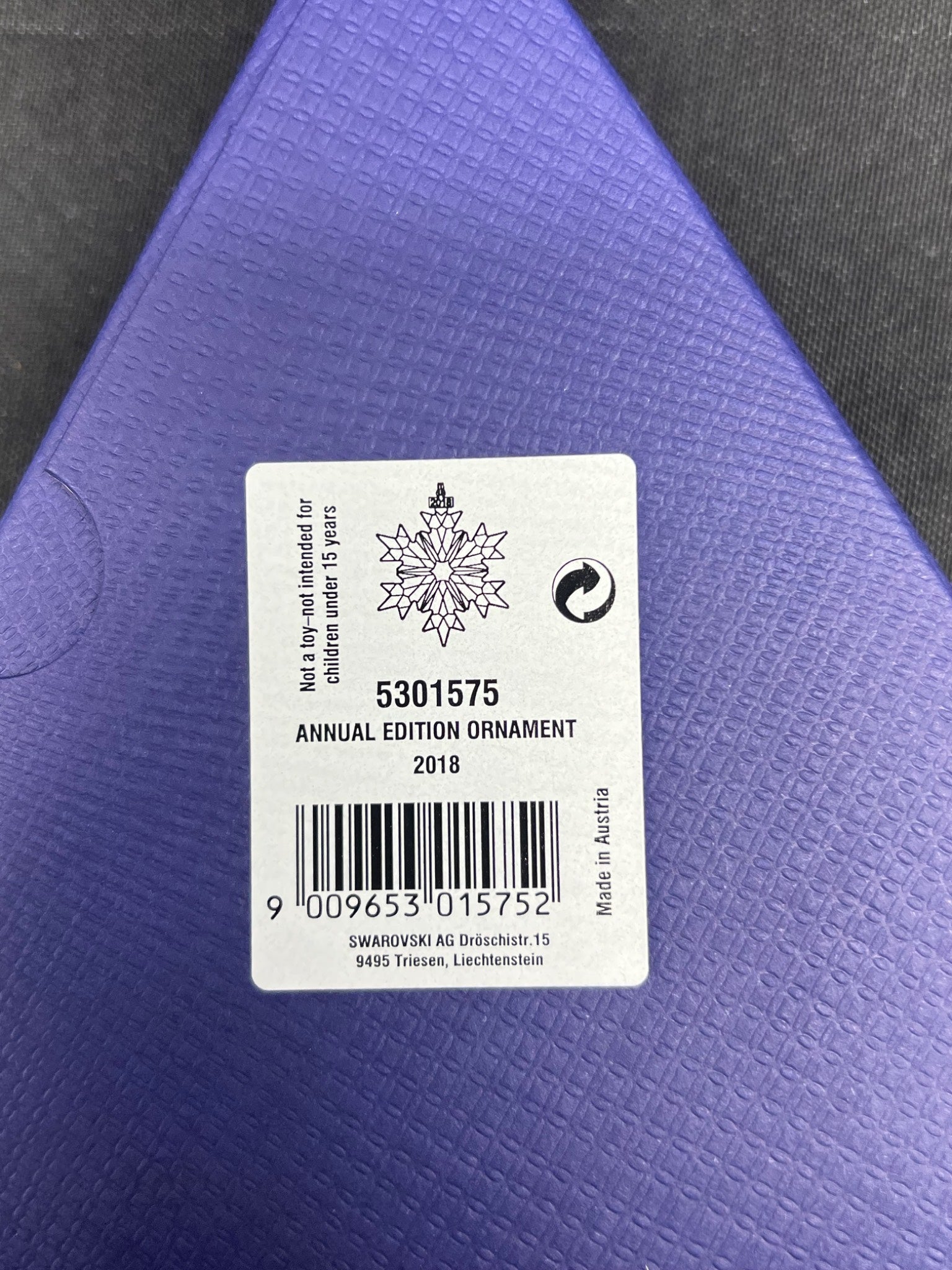 Swarovski annual edition ornament label on a purple background
