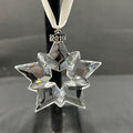 Crystal star ornament with '2019' on a black stand against a gray background