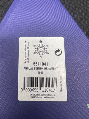Label on a purple ornament with Swarovski branding and product details.