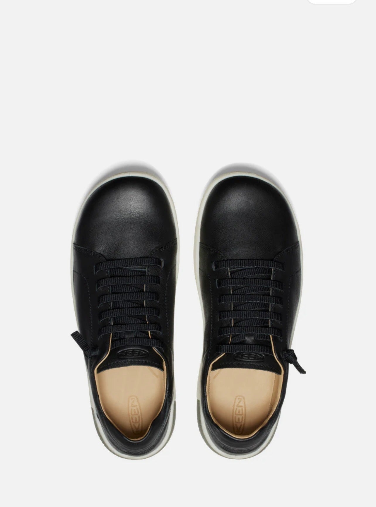 Black sneakers with beige soles on a white background