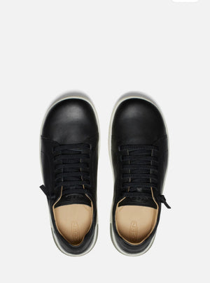 Black sneakers with beige soles on a white background