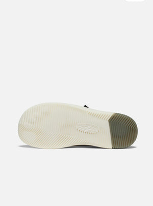 Close-up of a shoe sole with a white sole and brown sole on a light gray background