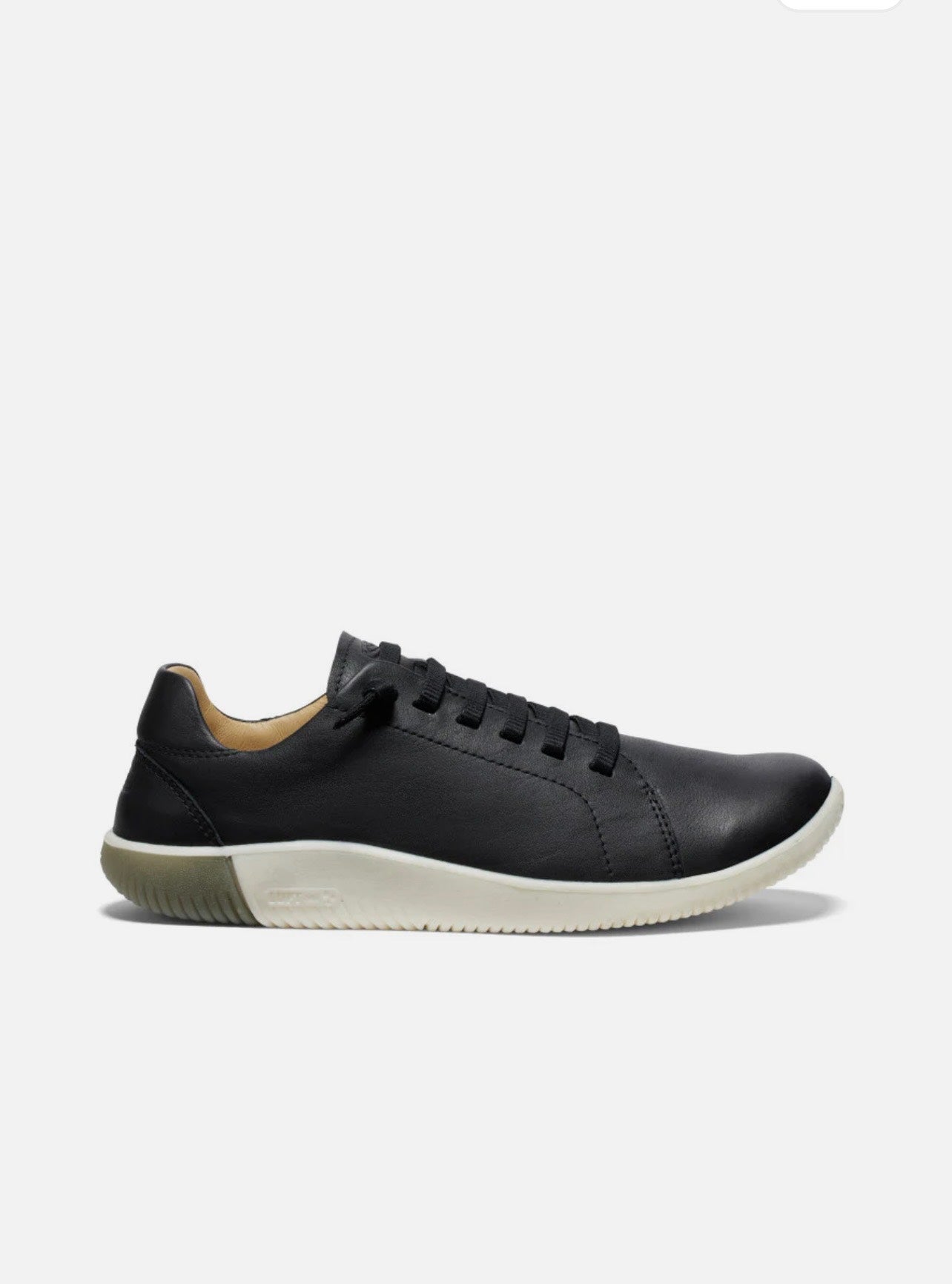 Black sneaker with white sole on a light gray background