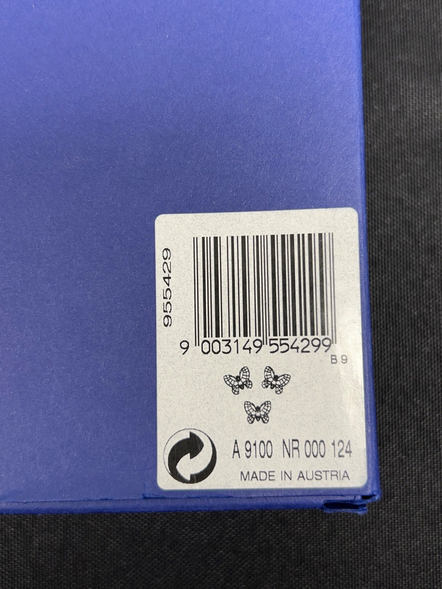 Bar code label on a blue surface with text and symbols.