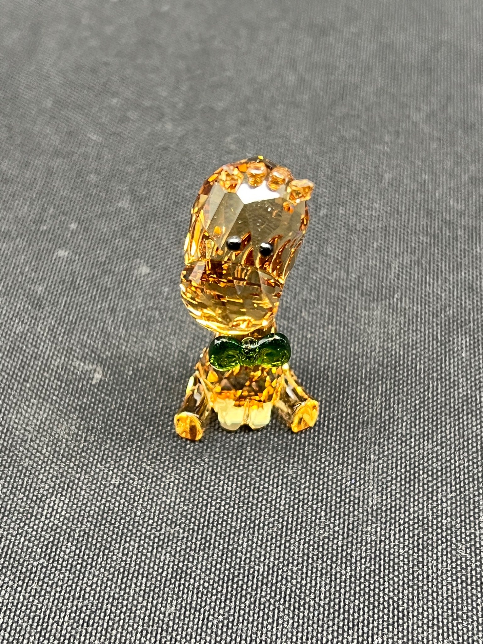 Gold-colored decorative object on a gray fabric background