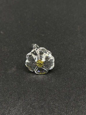Clear glass flower with yellow center on a black background