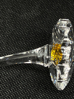 Close-up of a clear crystal object on a black textured background