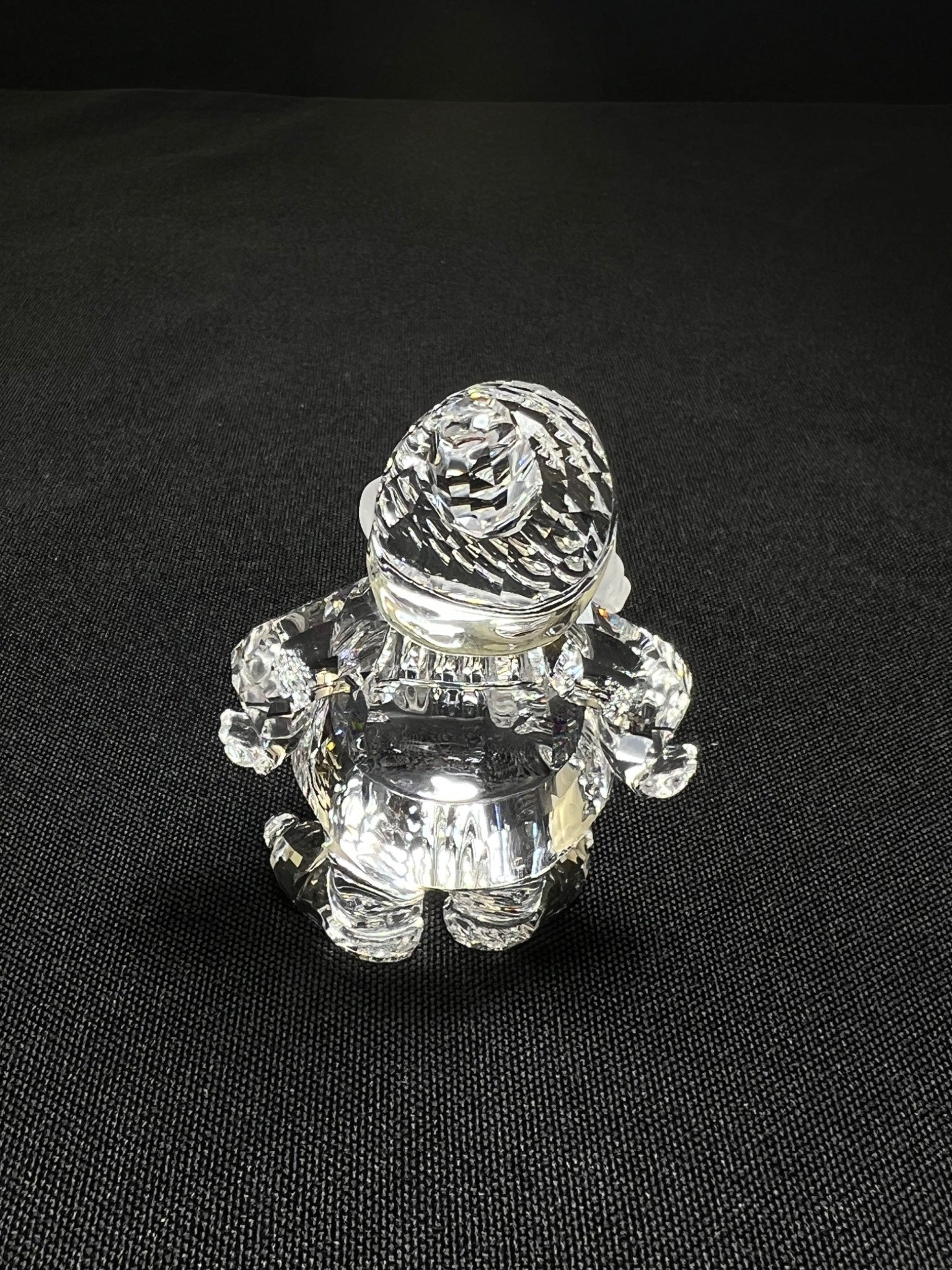 Crystal figurine of a small creature on a black background