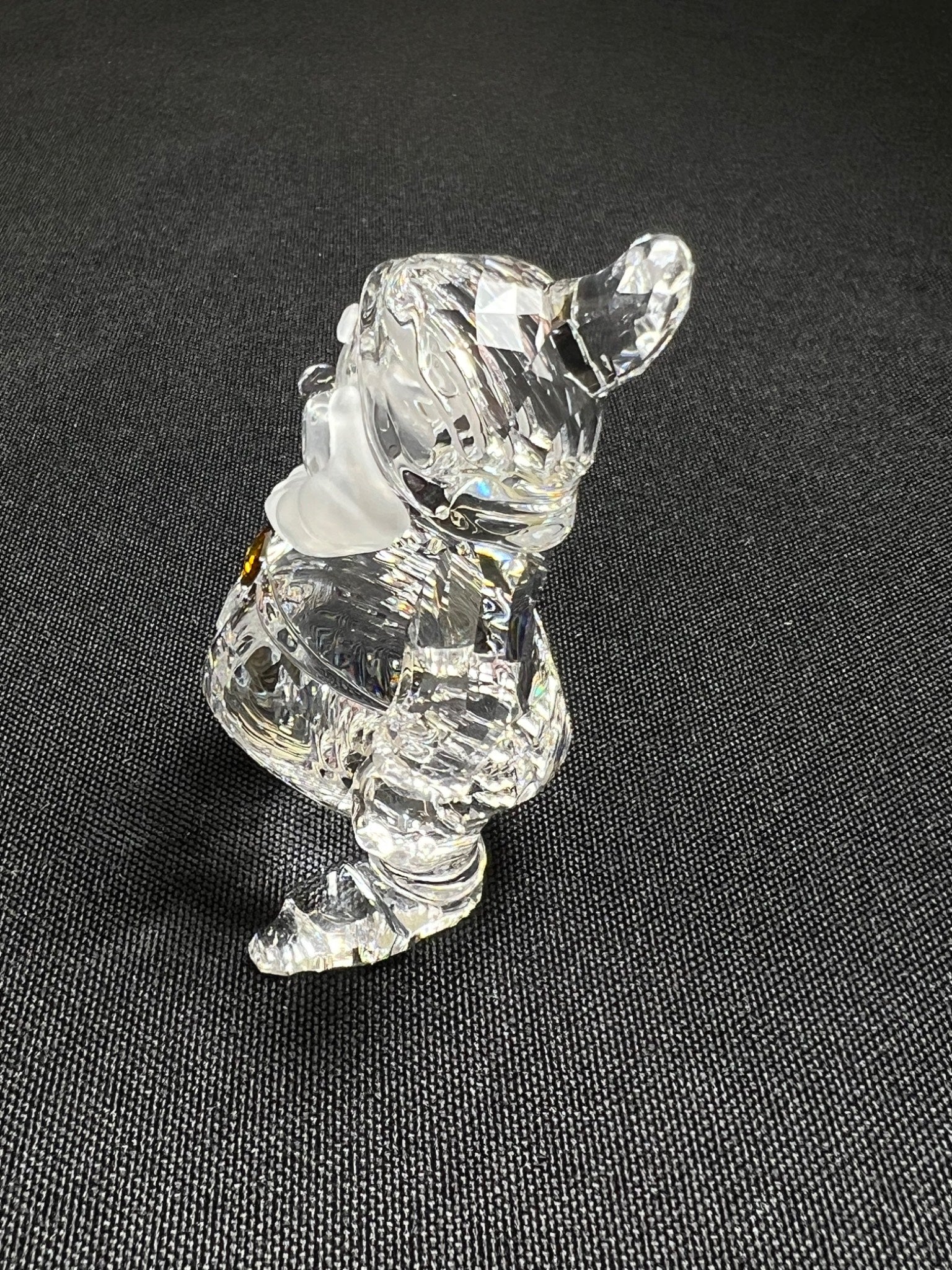 Clear glass bear figurine on a dark textured surface
