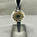 Decorative pendant with gold intricate design on a clear background