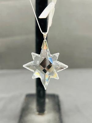 Crystal star ornament on a stand with a neutral background