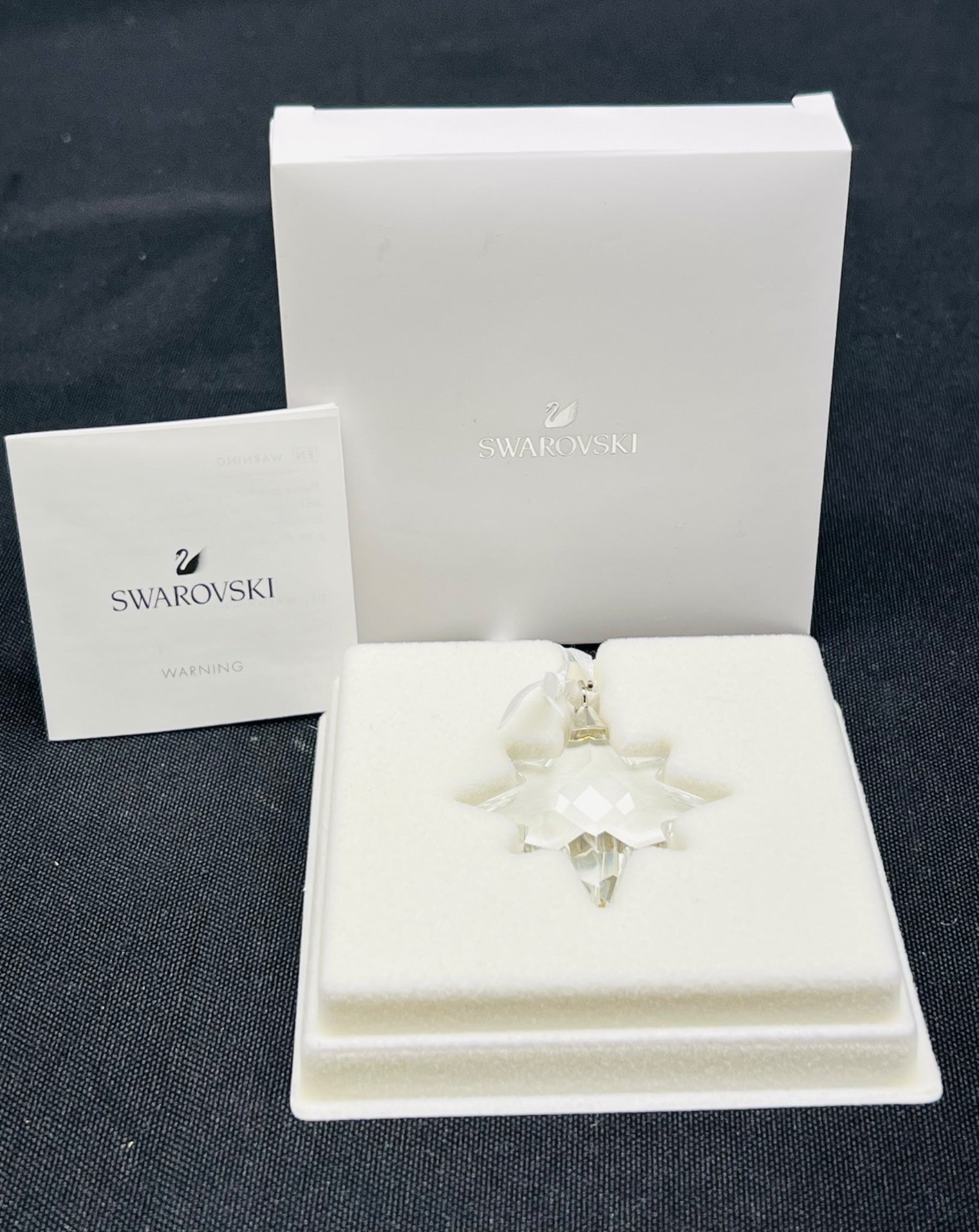 Swarovski crystal ornament in a box on a dark surface