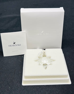 Swarovski crystal ornament in a box on a dark surface