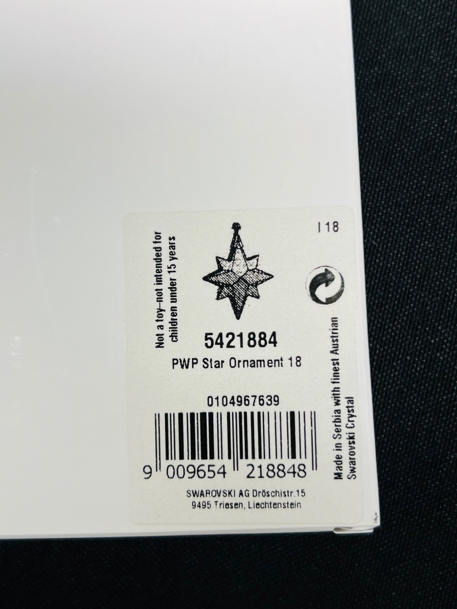 Close-up of a Swarovski crystal ornament label with product details.