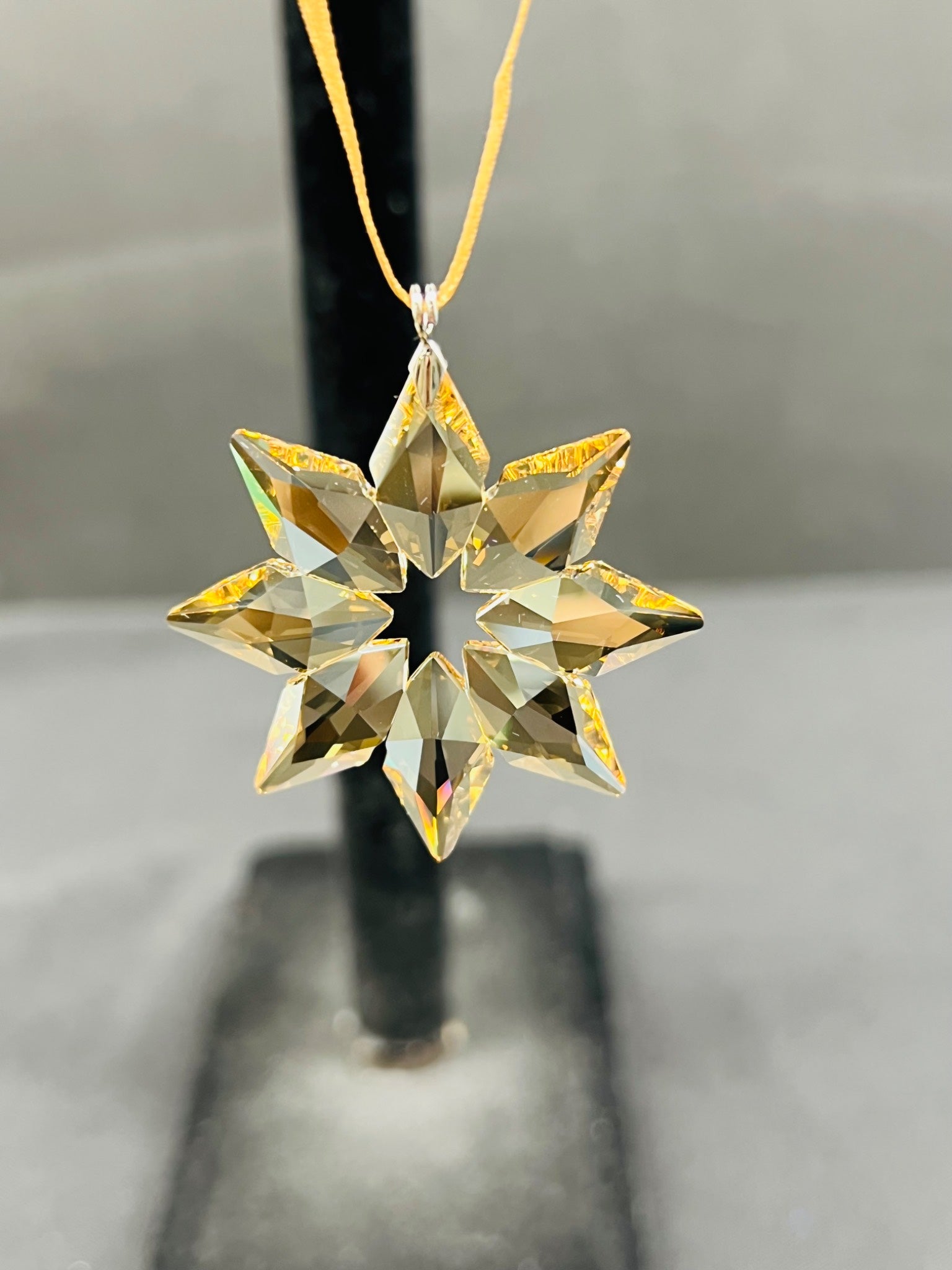 Gold star-shaped ornament on a neutral background