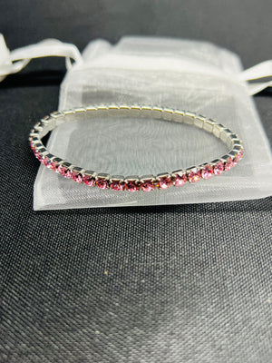 Silver bracelet with pink stones on a gray surface