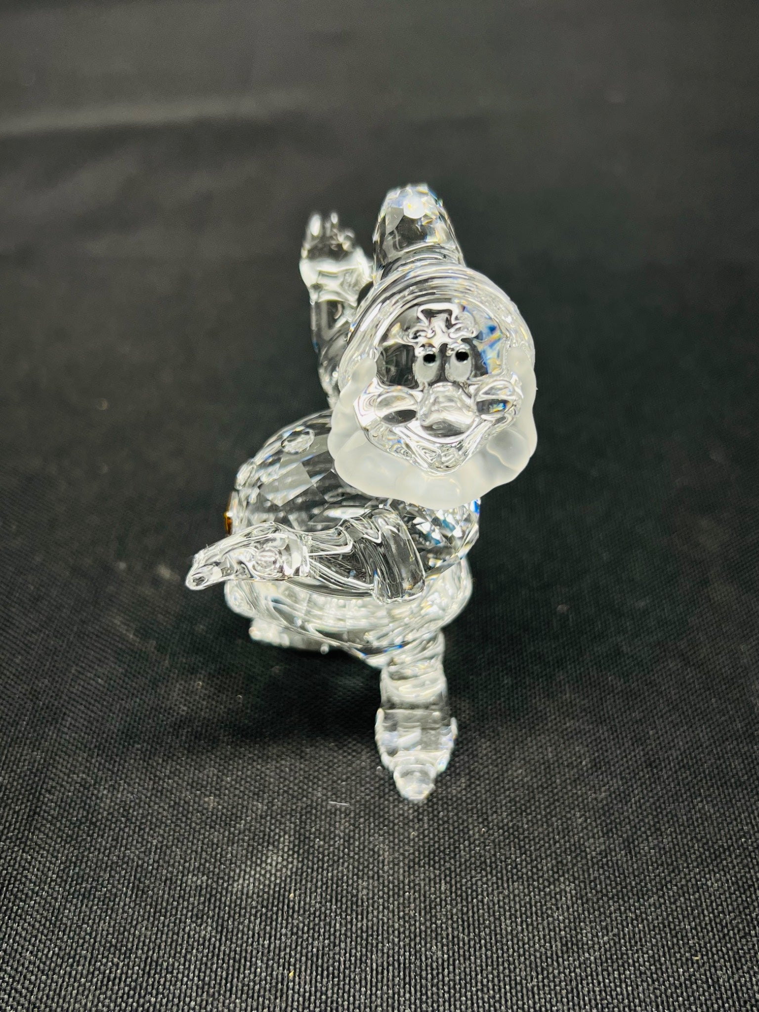 Clear glass figurine of a dragon on a black background