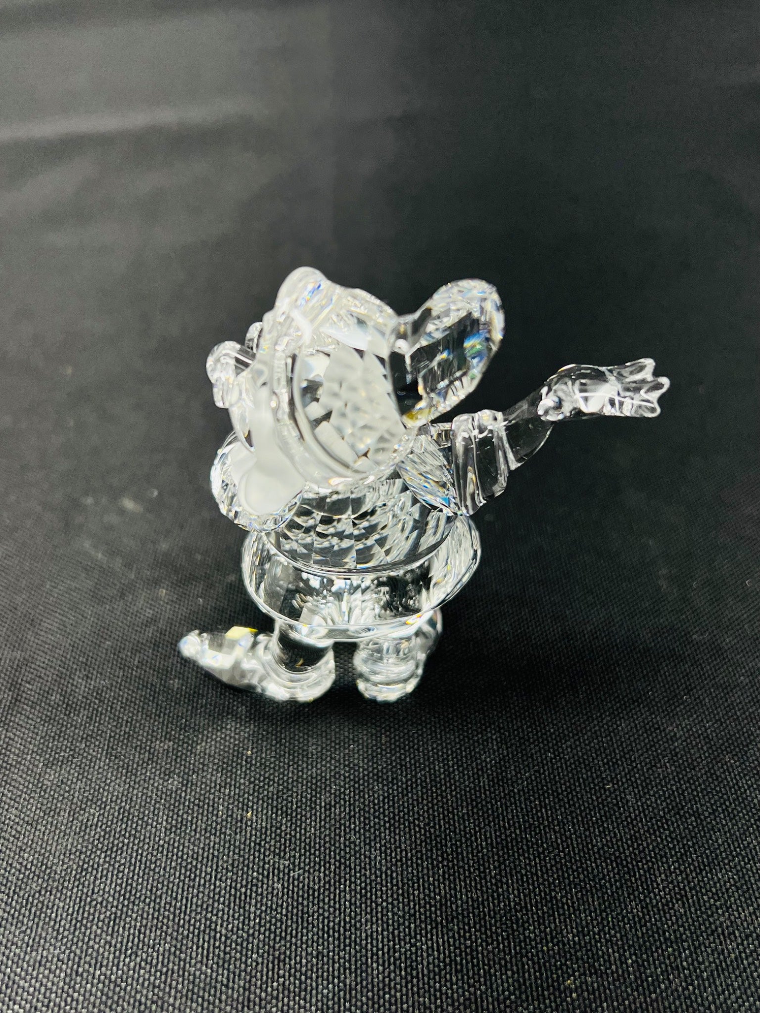 Clear crystal figurine of a character on a black background