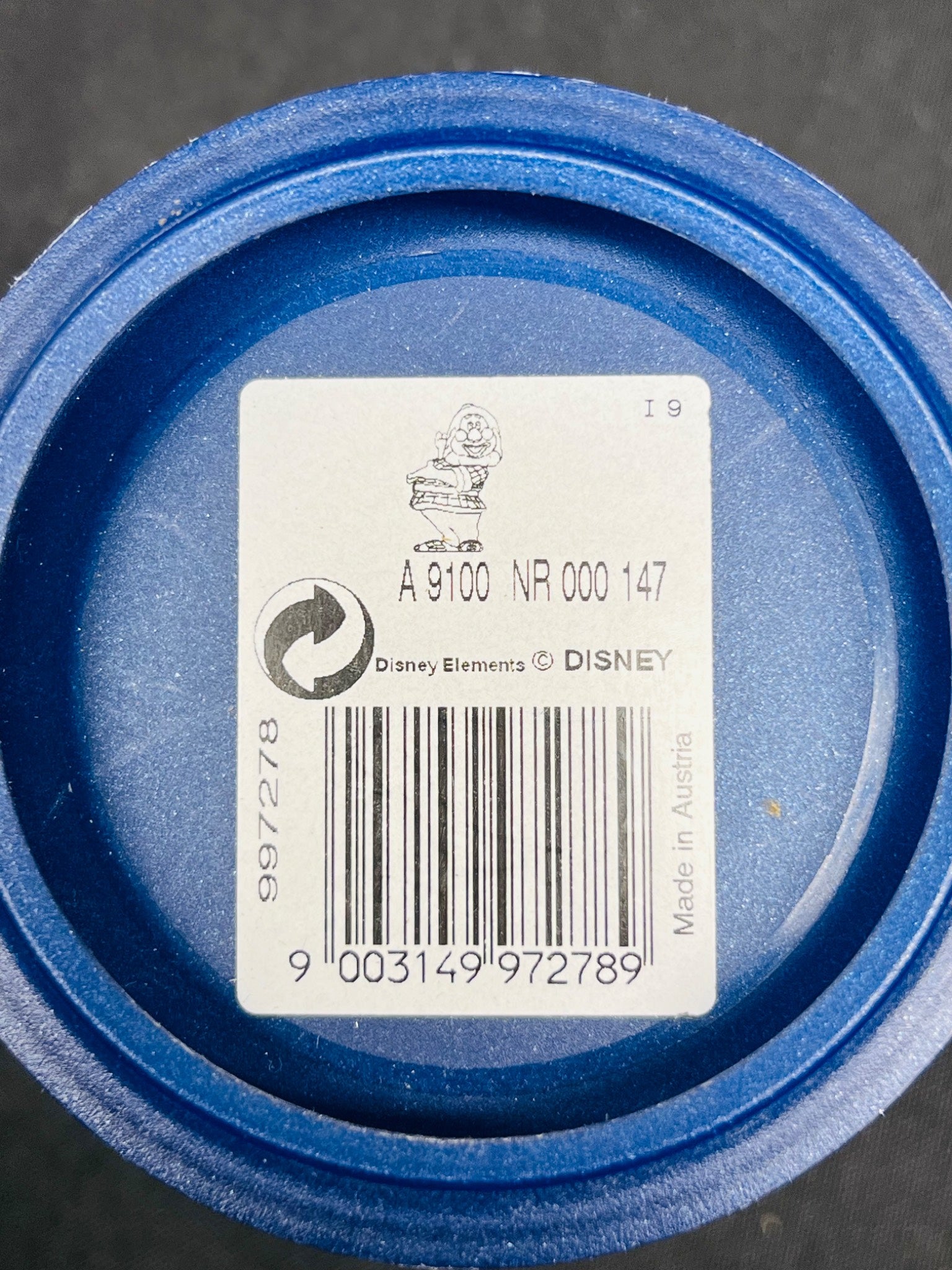 Close-up of a blue container lid with a label featuring a barcode and Disney branding.