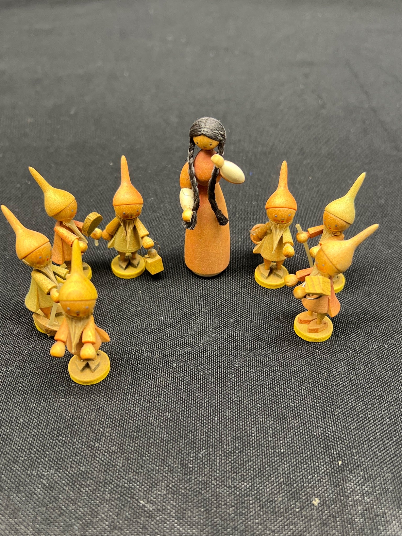 Set of figurines with a central figure on a dark textured background