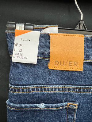 Close-up of blue jeans with a brand tag on a black background