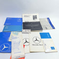 Collection of Mercedes-Benz manuals and documents on a white background