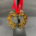 Gold star-shaped ornament on a stand with a red ribbon