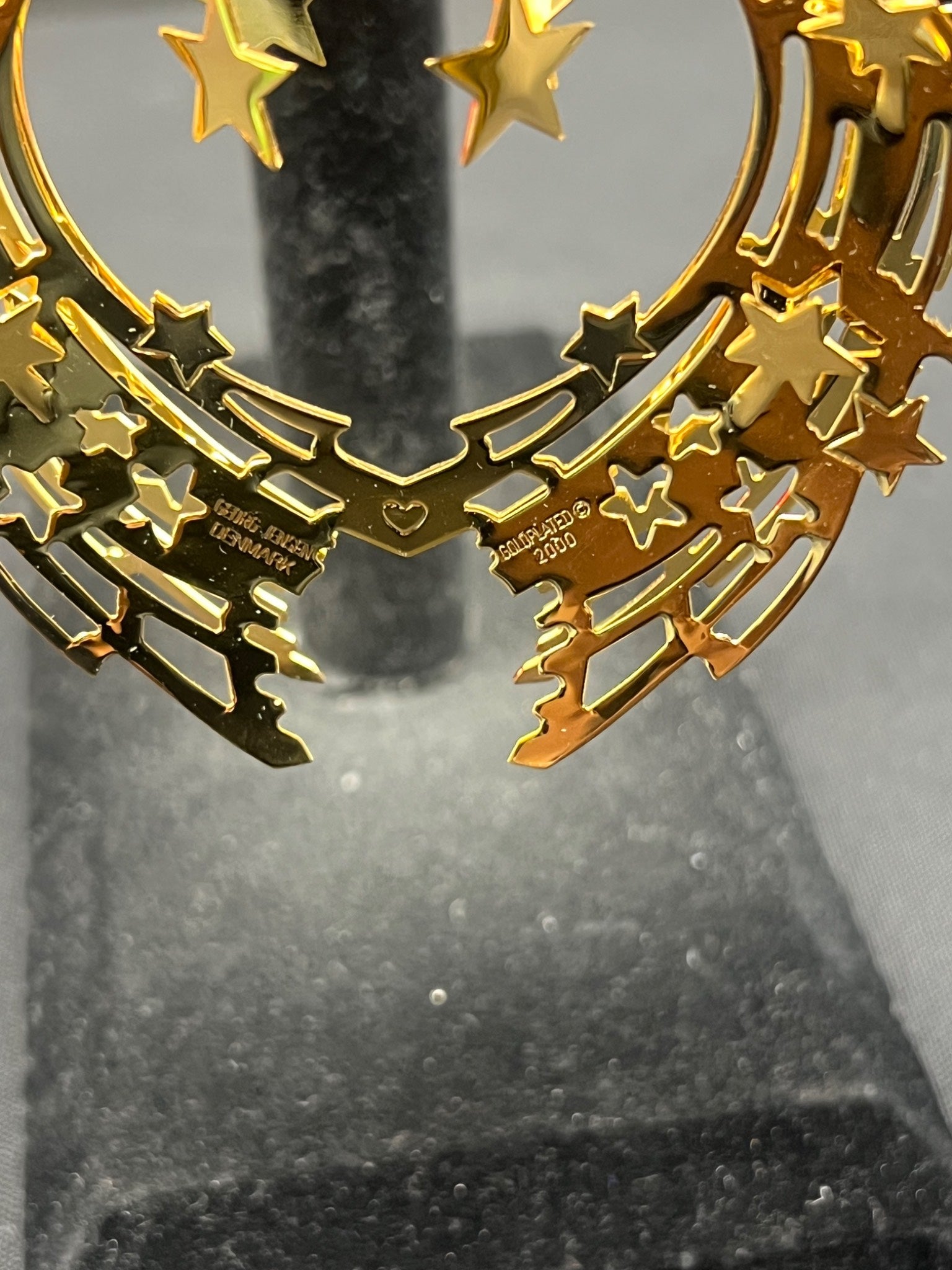 Gold decorative item with stars on a gray background