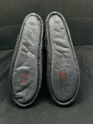 Two gray slippers with mesh design on a black background