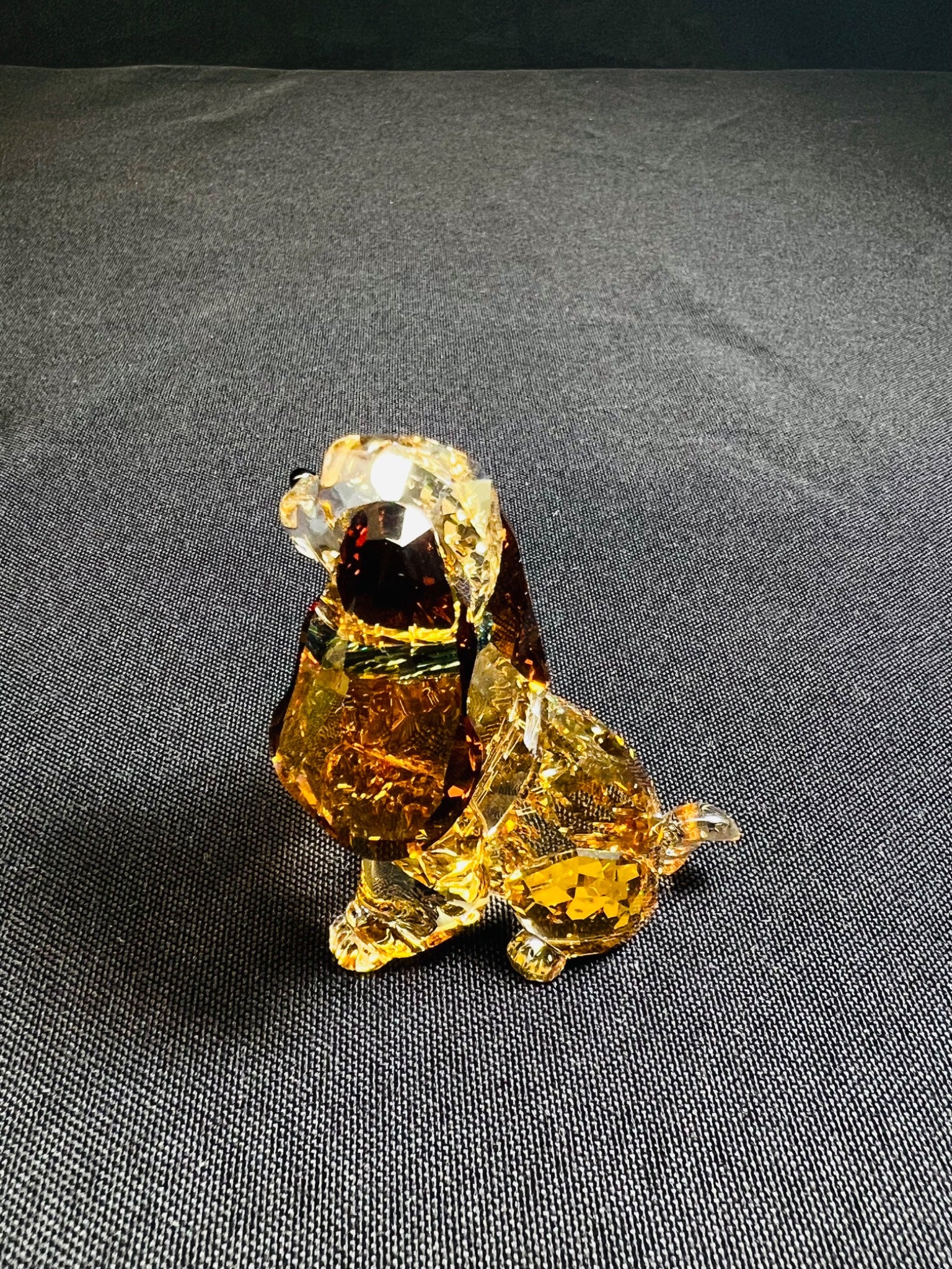 Crystal dog figurine on a gray fabric background