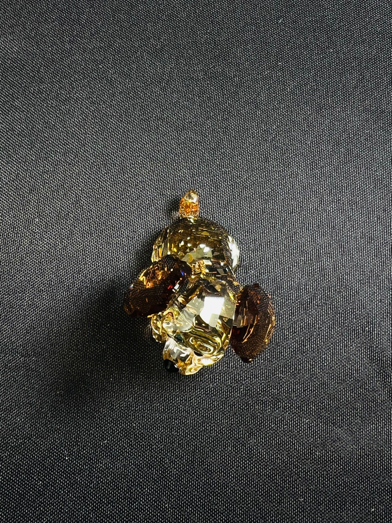 Decorative brooch with gemstones on a dark fabric background