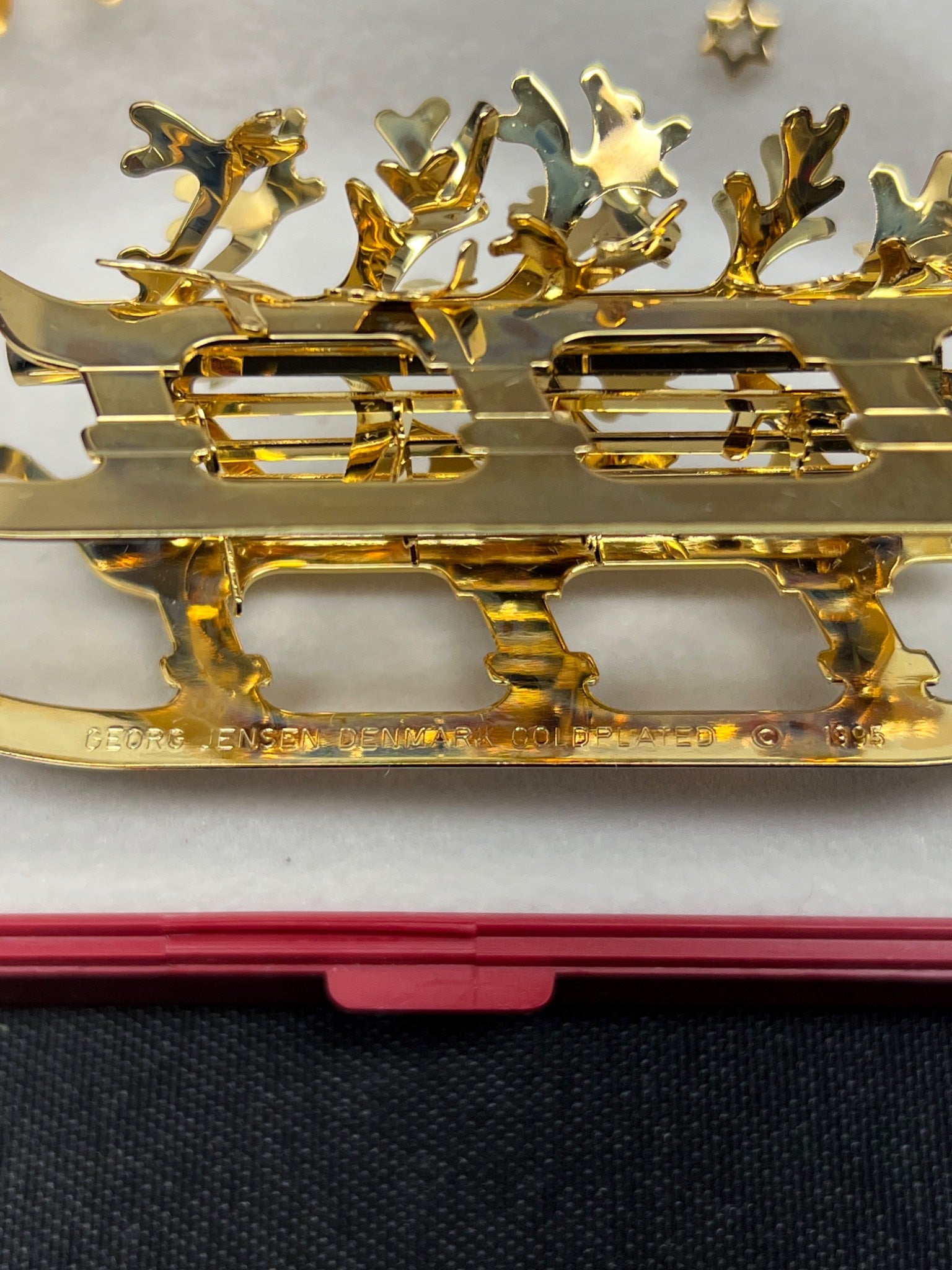 Gold decorative item with intricate designs on a black surface